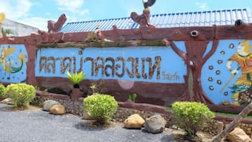 A decorative wall with Thai script and a bird sculpture.