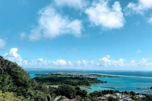 A coastal landscape with a clear sky, a view of the sea, and a distant island. - Lala Court Seaside Yagaji (Nago)