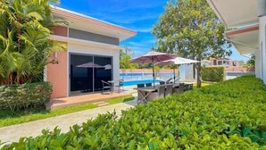 A modern building with a pool area, outdoor seating, and lush greenery. - The Memories Hill Phuket (Phuket)