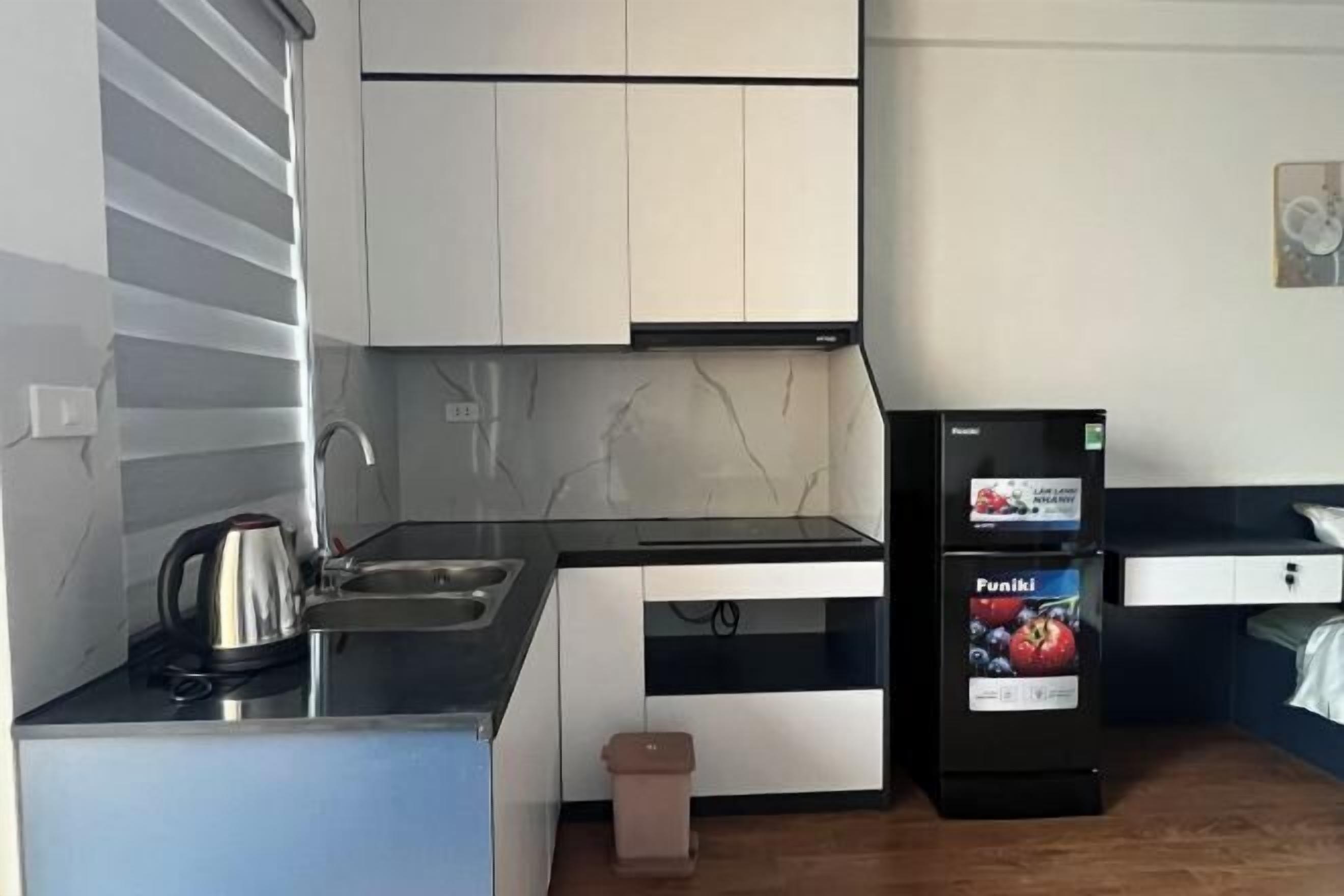 A compact kitchen with a sink, stove, and a refrigerator with a freezer.