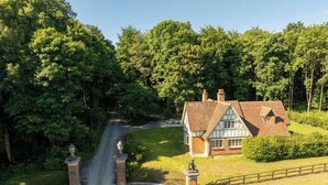 A house with a traditional design, surrounded by lush greenery and a well-maintained lawn. - Badgers Bolt - Idyllic rural apartment (Hungerford)