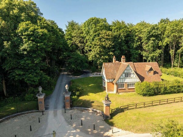 A house with a traditional design, surrounded by lush greenery and a well-maintained lawn.