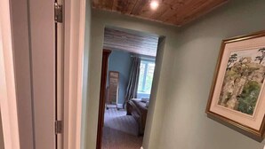 A hallway with a wooden ceiling, carpeted floor, and a framed picture on the wall. - Badgers Bolt - Idyllic rural apartment (Hungerford)