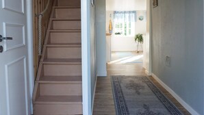 A staircase leading to a room with a view of a garden through a window. - 6 Person Holiday Home in Lysekil (Lysekil)