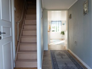 A staircase leading to a room with a window, a rug on the floor, and a plant in the corner. - 6 Person Holiday Home in Lysekil (Lysekil)