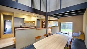Un intérieur moderne comprenant un coin repas, une cuisine et un espace détente près d’une fenêtre.