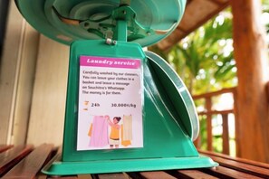 A green laundry service sign with a 24-hour service and a rate of 30.000/kg. - Souchitra Riverside Guesthouse (Champasack District)