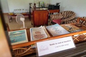 A reading area with books and a sign indicating it's a spot to read at Souchitro. - Souchitra Riverside Guesthouse (Champasack District)