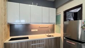 Een moderne keuken met een ingebouwd spoelbakje, houten kastjes en een roestvrijstalen koelkast.