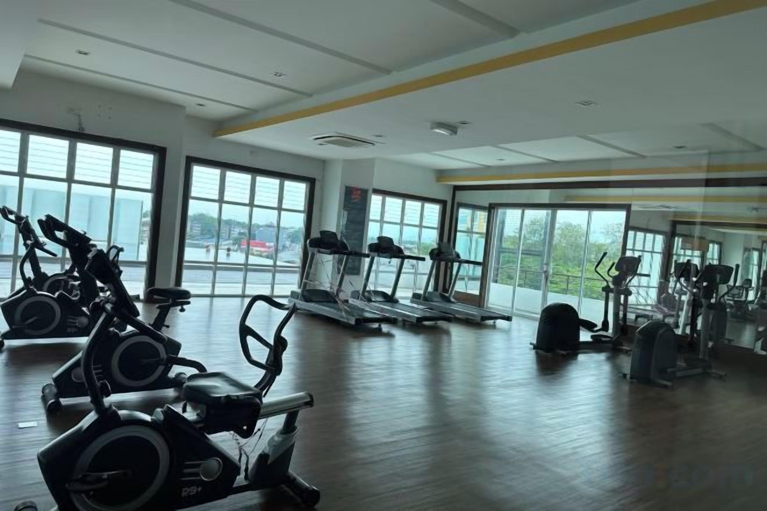 Academia equipada com aparelhos de cardio, esteiras e máquinas de peso.