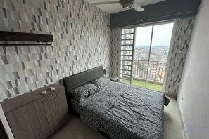 Un dormitorio con cama, mesita de noche, ventana con vistas y ventilador de techo.