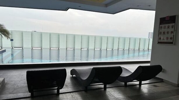 Een modern binnenzwembad met ligbedden en een glazen balustrade met uitzicht op het zwembad.