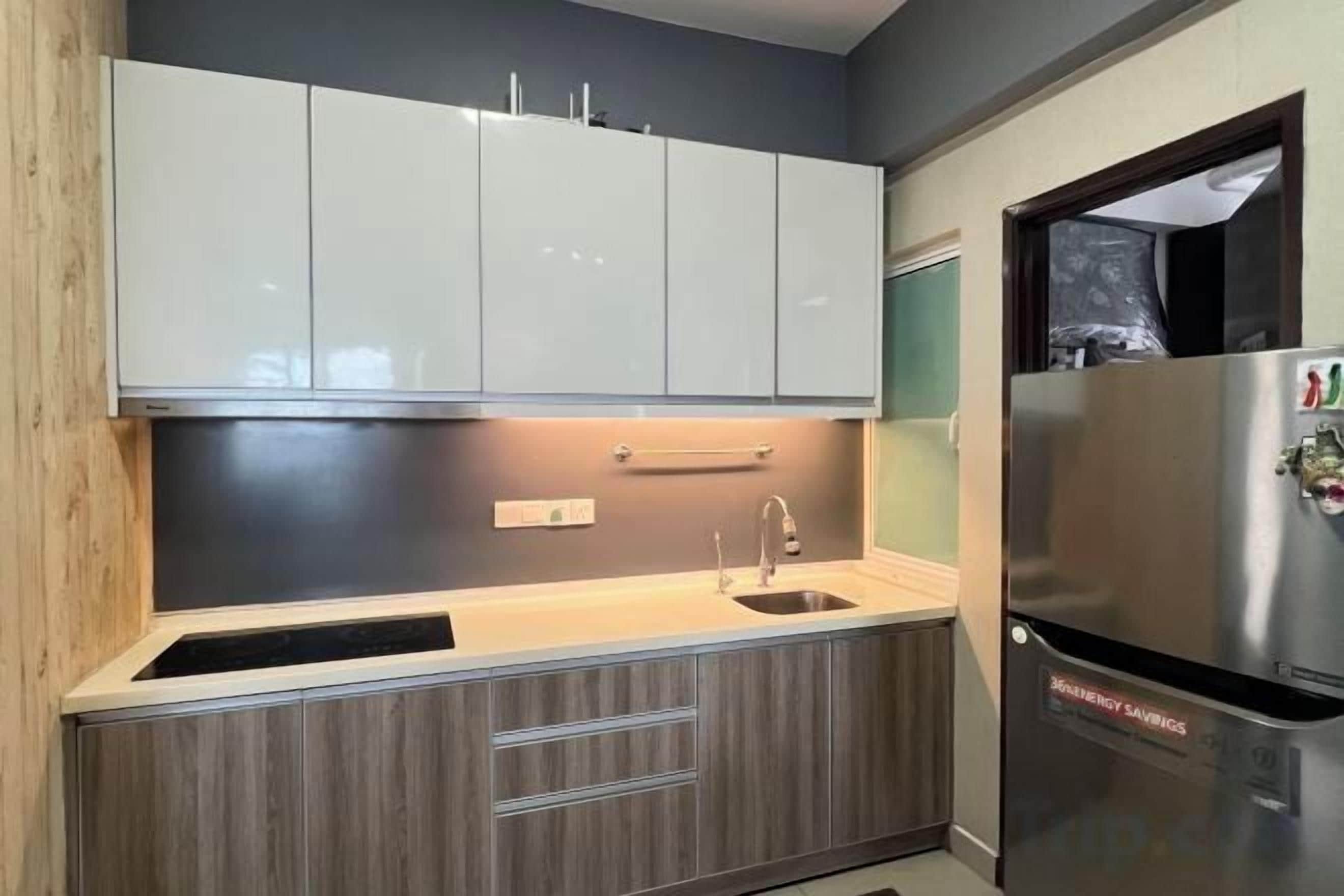 A modern kitchen with a stainless steel refrigerator, a double sink, and wooden cabinets.