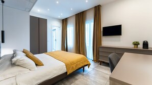 Habitació d'hotel moderna amb llit, escriptori, televisió i cafetera.