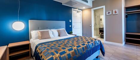 A modern bedroom with a large bed, a bedside table, a wardrobe, and a walk-in closet.
