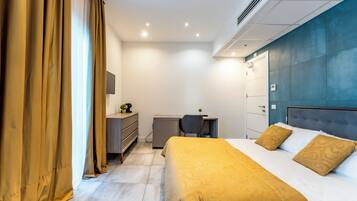 Een moderne hotelkamer met een bed, bureau en garderobe.