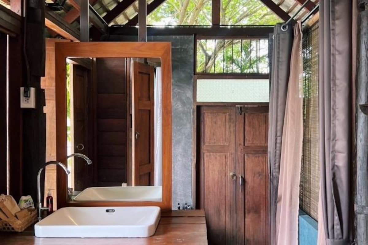 A bathroom with a large mirror, a sink, and wooden doors.