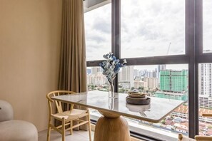 A dining area with a table, chairs, and a vase of flowers. - Designer Suites George Town + LG Water Purifier【City View】 (Jelutong)