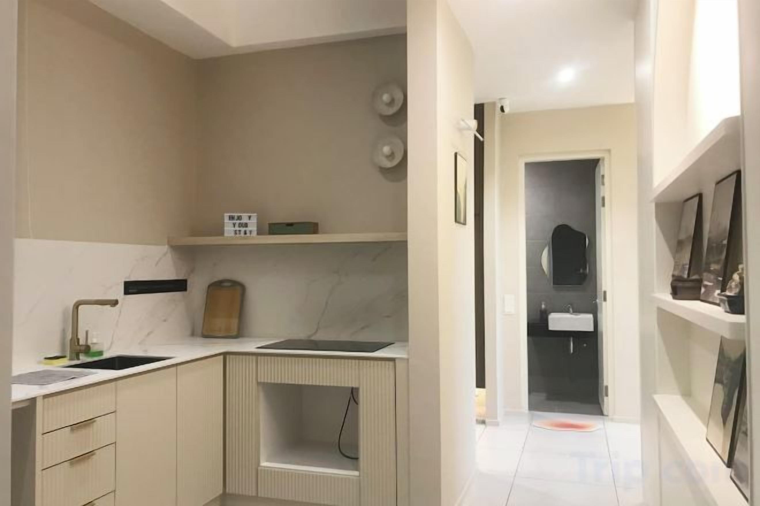 A compact kitchen with a sink, countertop, and cabinets.