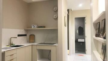 A compact kitchen with a sink, countertop, and cabinets.