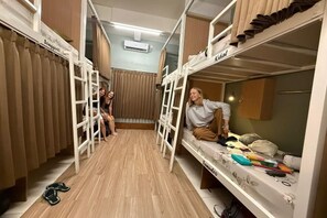 A dormitory room with bunk beds, a ladder, and a pair of shoes on the floor. - Little Malang Hostel (Klojen)