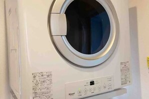 Vista frontal de una lavadora con panel de control y manual de instrucciones.