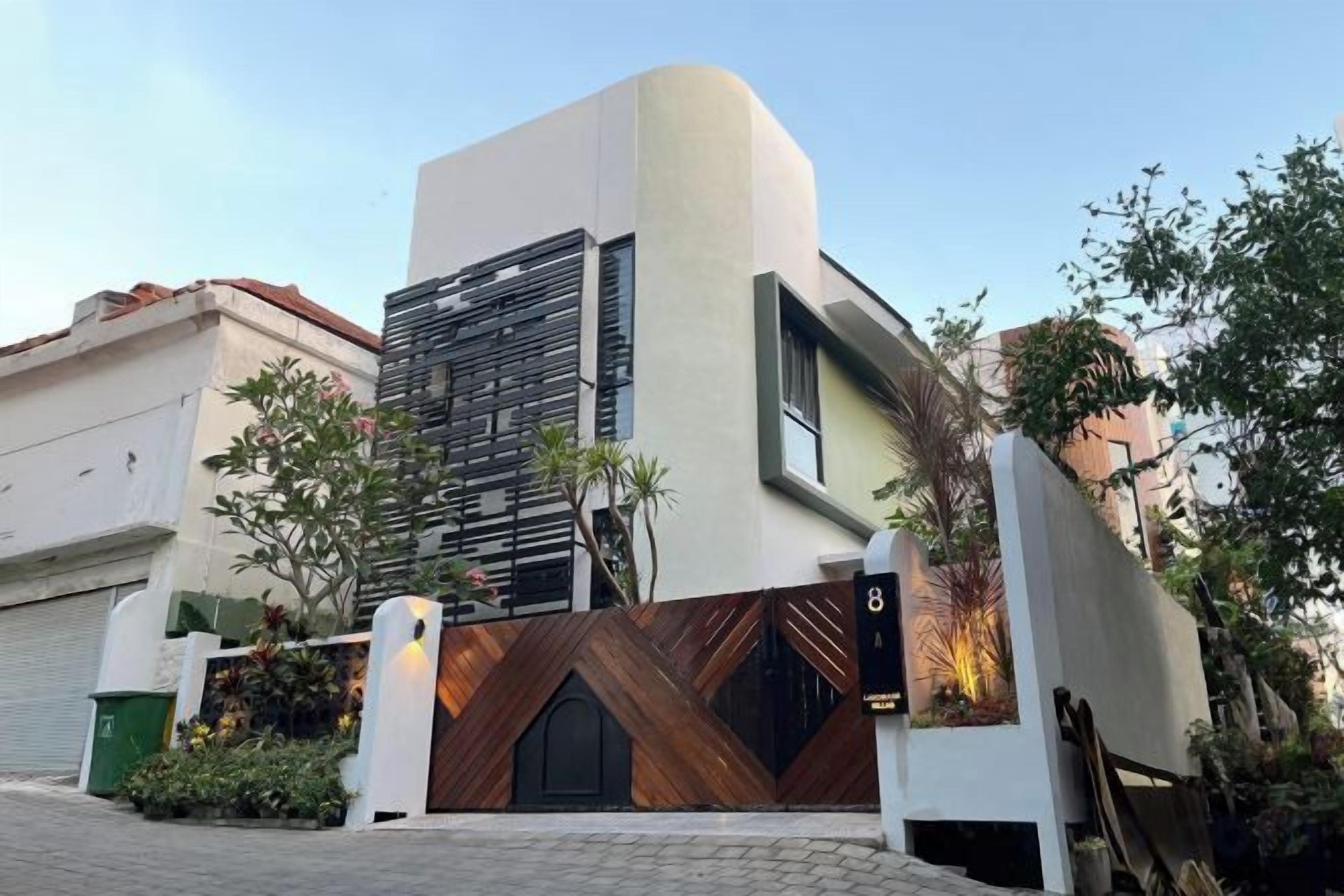 A modern building with a unique architectural design, featuring a curved facade and a prominent entrance with a wooden gate.