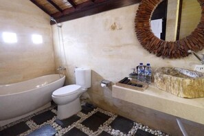 Een badkamer met een bad, toilet en wastafel.