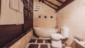 A bathroom with a freestanding bathtub, a toilet, and a shower area. - Kayu Manise Villa Bedugul (Bali)