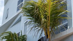 A building with a modern architectural style, featuring a balcony with a railing. - Coco & Pineapple Pants Hostel (Bali)