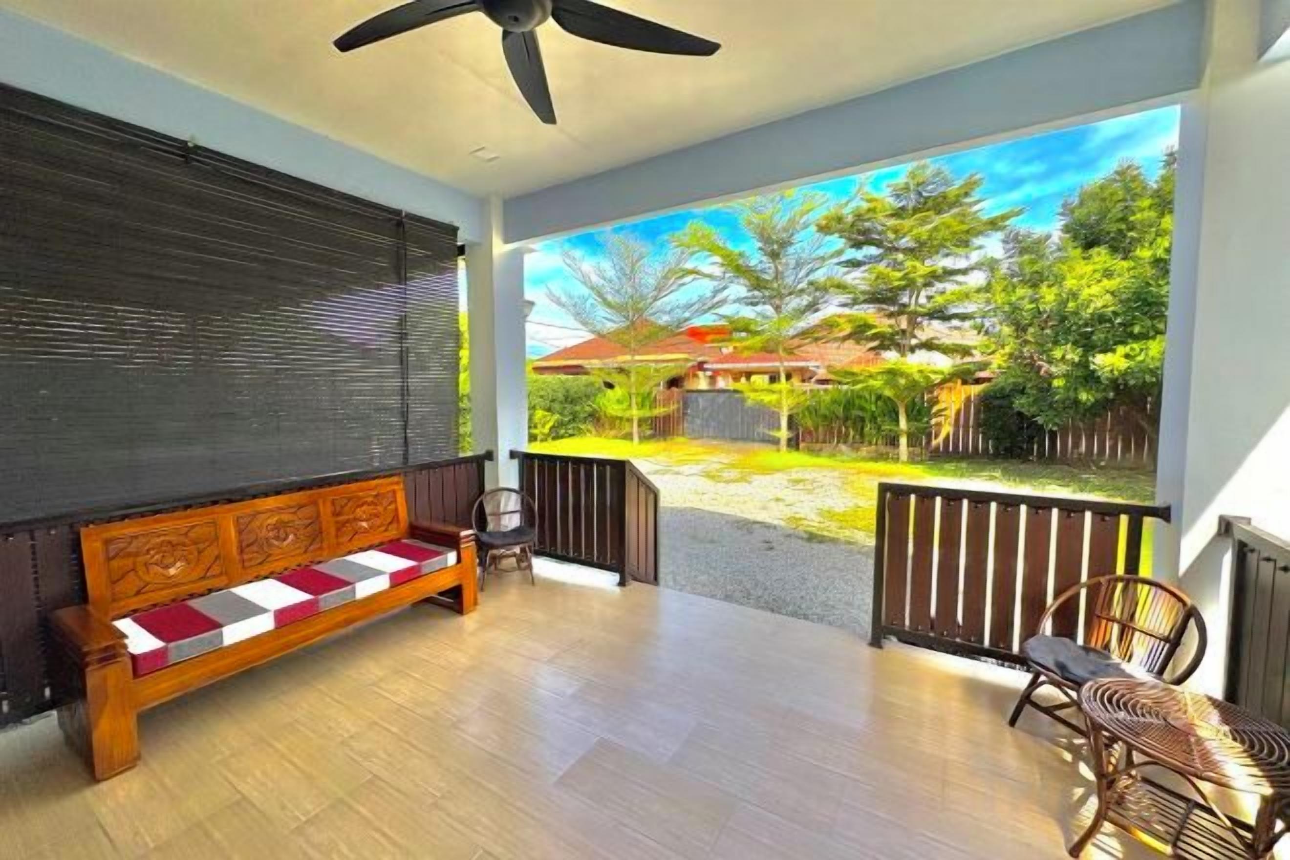 A room with a wooden bench, a chair, and a view of a garden.