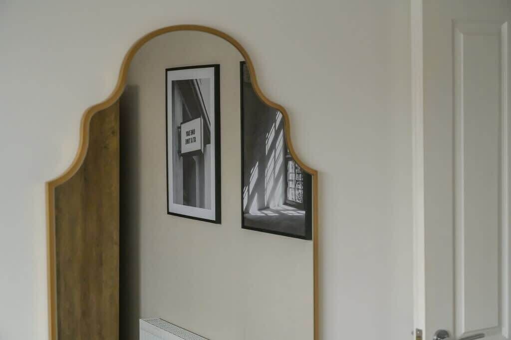 Una stanza con stipite in legno e due fotografie incorniciate appese al muro.