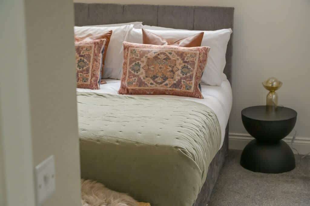 Une chambre à coucher avec un lit, des oreillers et une table de chevet.
