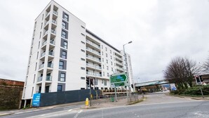 Un immeuble à plusieurs étages doté d’une architecture moderne, avec des balcons à chaque niveau.