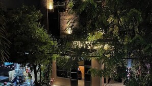 A modern building with a brick facade, large windows, and a well-lit entrance. - Kim’s House Entire Villa 6-BR Near My Khe Beach (Da Nang)