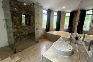 A modern bathroom with a glass-enclosed shower, a freestanding bathtub, and a large vanity with a mirror. - Kim’s House Entire Villa 6-BR Near My Khe Beach (Da Nang)