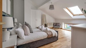 A bedroom with a bed, a desk, a chair, and a skylight. - 5-bedroom apartment with river views - Goliath (Belfast)