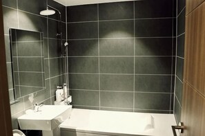Une salle de bain avec un lavabo, un miroir et une baignoire.