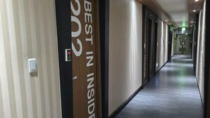 Un couloir avec une pancarte indiquant « MEILLEUR EN MAGASIN » et une porte dotée d’un clavier pour l’ouverture à code.