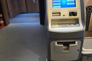A self-service kiosk with a screen, card reader, and cash slot. - Best in Hotel (Siheung-si)
