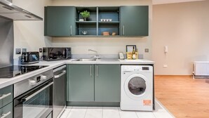 A modern kitchen with a built-in washing machine, a microwave, and a toaster.