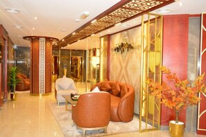 A lobby with a reception desk, seating area, and a decorative plant. - Concorde Palace Hotel (Dubai)