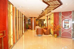 A hotel lobby with a polished floor, seating area, and a reception desk. - Concorde Palace Hotel (Dubai)