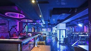 A modern restaurant with a bar area, seating, and a neon-lit ceiling. - Concorde Palace Hotel (Dubai)