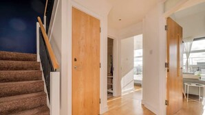 Un interno moderno con una scala, porte in legno e una stanza luminosa con vista.