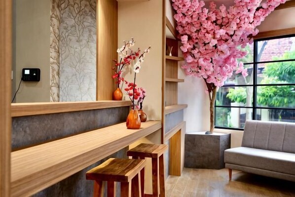 Ein modernes Interieur mit HolzbĂ€nken, einer Couch und einem groĂen Fenster mit Blick auf GrĂŒnflĂ€chen.