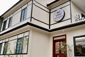 A building with a traditional architectural style, featuring a prominent sign with the name 'TOKAN' and a logo. - The Ryokan Semarang (Semarang)