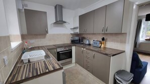 A modern kitchen with a built-in oven, microwave, and a stainless steel range hood.