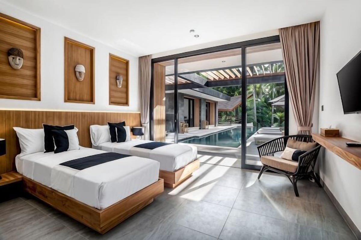 A hotel room with two beds, a TV, a pool view, and a balcony.