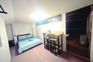 A small room with a bed, a desk, and a chair. - Panda Lodge Home Stay (Bangkok)